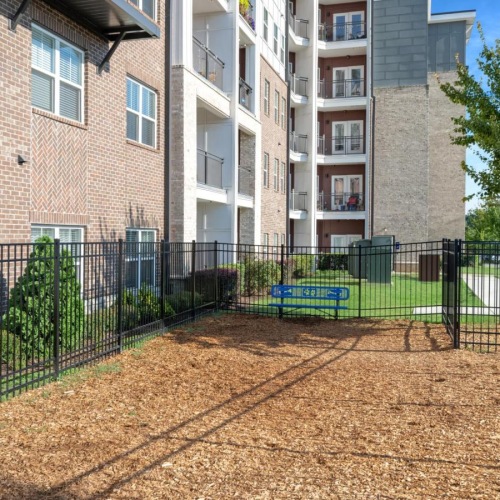 a fenced in area with a building in the background