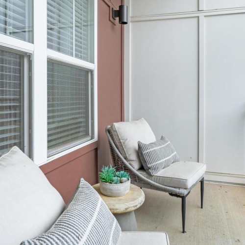a white chair and a white couch in a room with a window